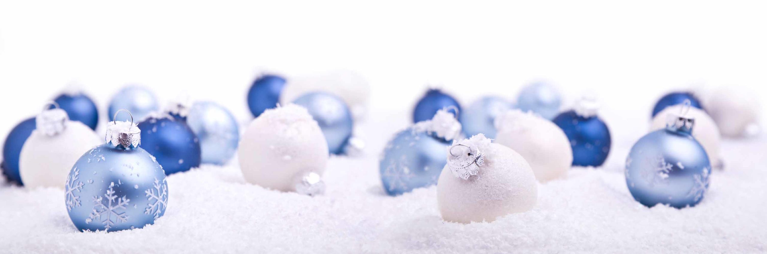 Christmas balls in light blue and white on snowy background